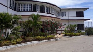 A two-story building with a curved facade, large windows, and a flat roof. - Tavua Hotel (Tavua)