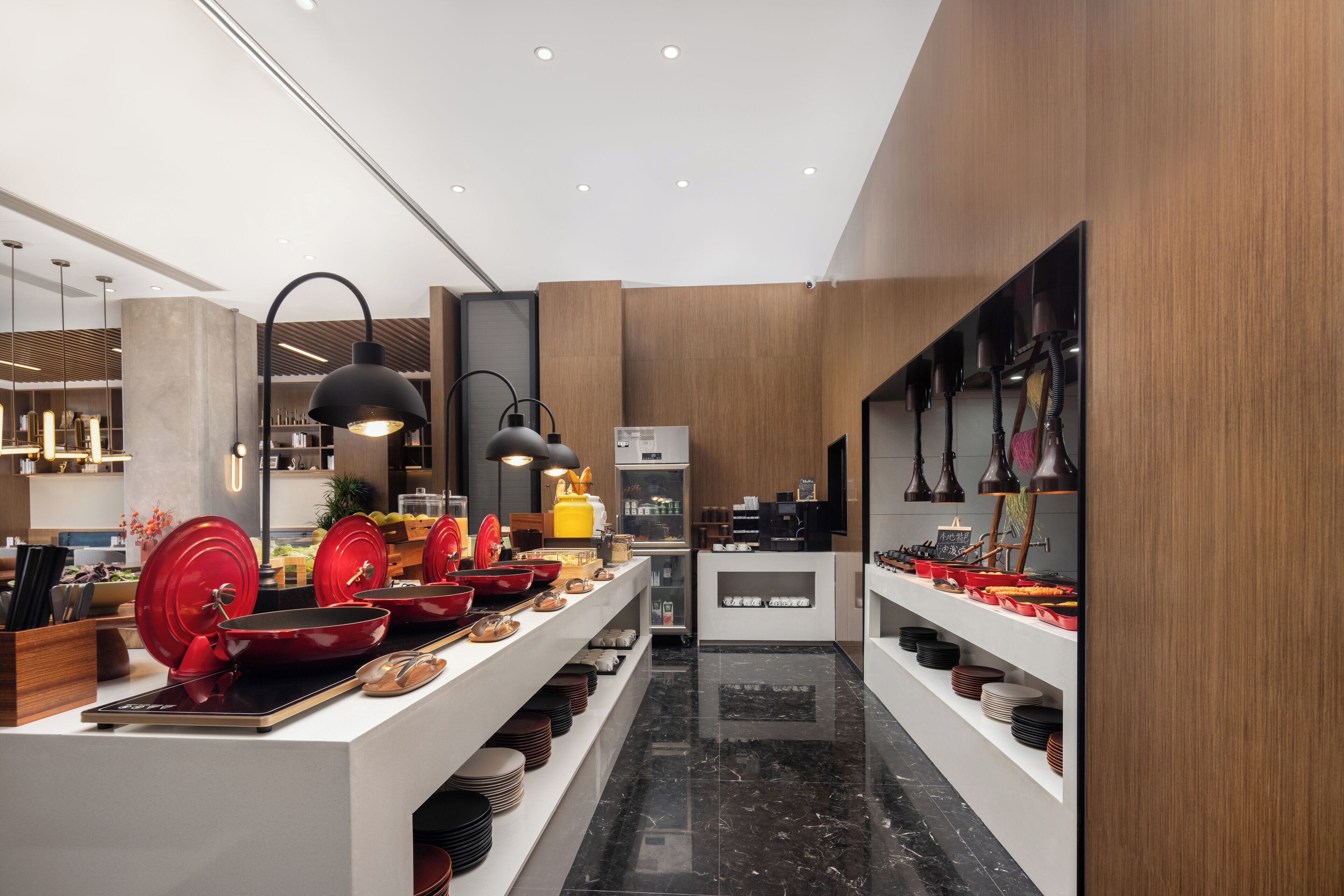 Una cocina moderna con armarios de madera, encimera de mármol y varios utensilios de cocina exhibidos en estantes.
