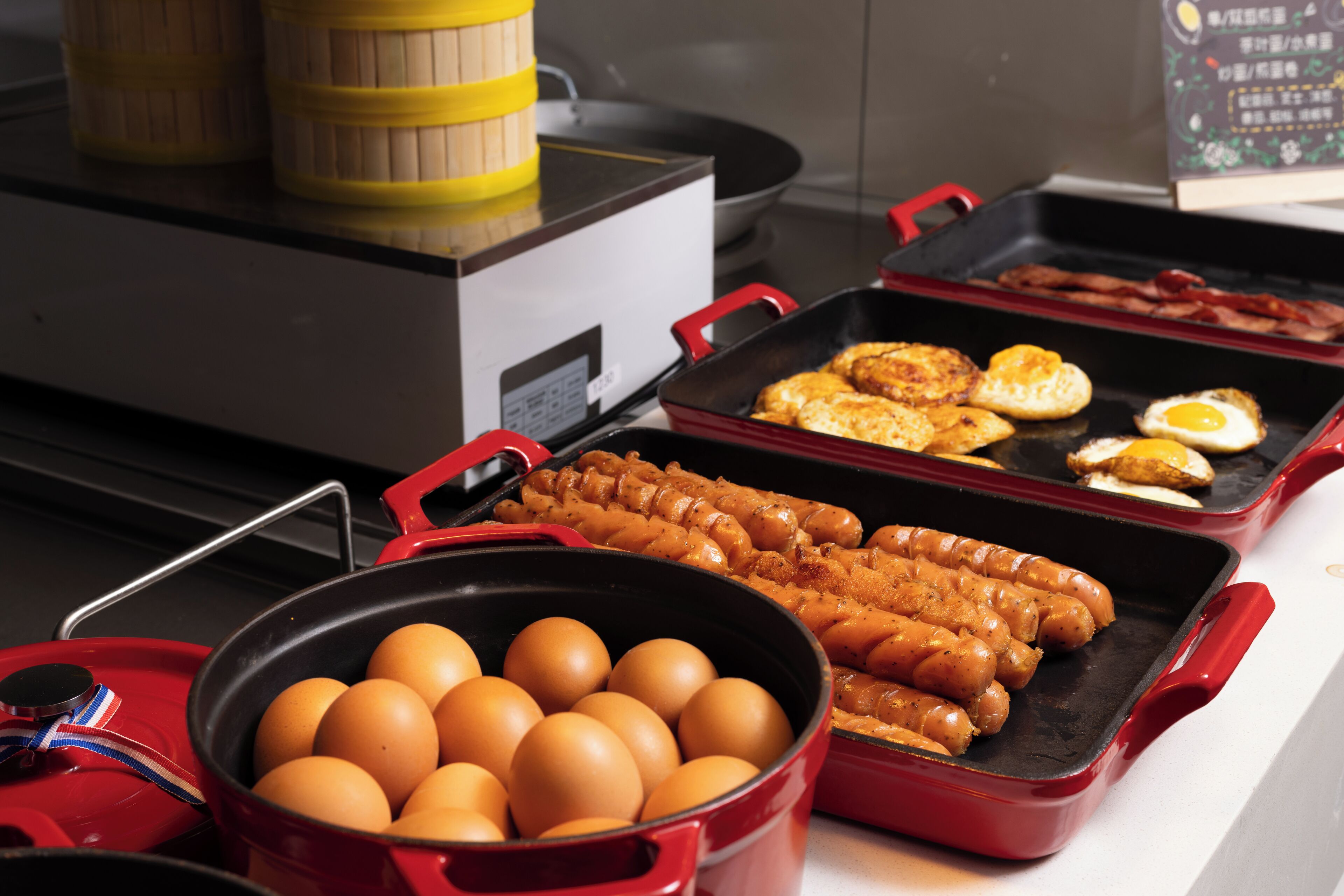A kitchen with a stove, a frying pan, and a pot of eggs.