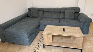 A grey sectional sofa with a wooden coffee table in front.