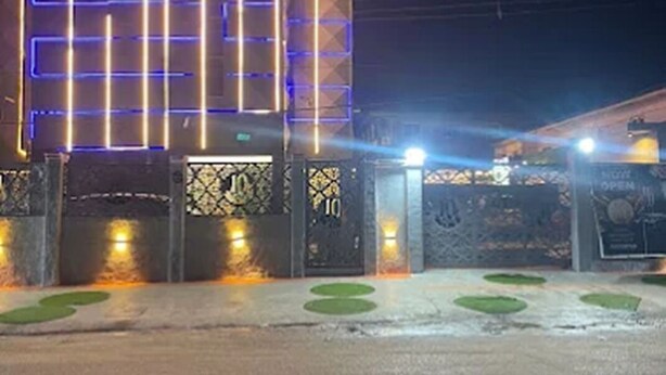 A building with a modern facade featuring illuminated geometric patterns and a prominent entrance gate. - 10 Kobo Hotel & Suites (Lagos)