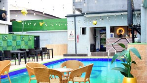 An indoor pool area with wicker chairs and tables, a bar area, and a sign prohibiting smoking of Indian hemp hard drugs. - 10 Kobo Hotel & Suites (Lagos)