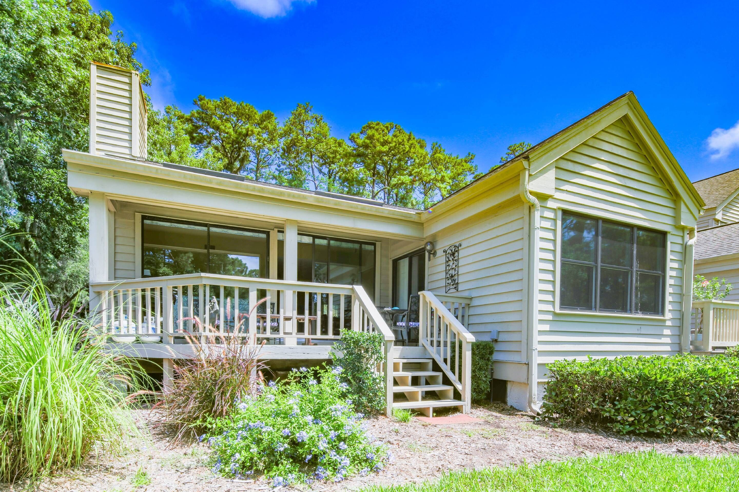 A two-story house with a front porch, a covered entryway, and a small garden area.