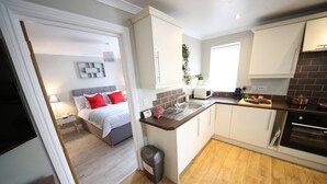 A compact kitchen with a central island, a built-in oven, and a microwave. - Number 4 Old Tiverton Rd (Exeter)