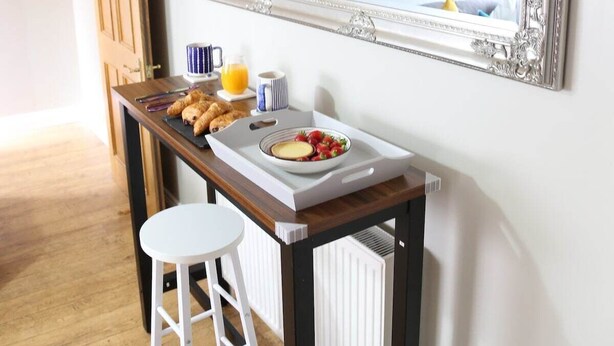 A breakfast setup with croissants, a bowl of fruit, and a cup of coffee on a tray. - Number 4 Old Tiverton Rd (Exeter)