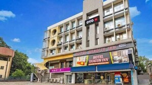A multi-story hotel with balconies, a prominent 'OYO' sign, and a 'Hotel Shagun Inn' sign. - hotel shagun inn  (Ahmedabad)