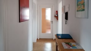 A hallway with a door, a wall-mounted phone, and a table with a book. - Apartment 'Kirsch-kern' with Balcony and Wi-Fi (Mössingen)