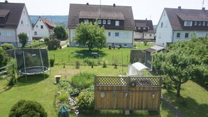 A residential area with houses, a trampoline, a fenced garden, and a wooden deck. - Apartment 'Kirsch-kern' with Balcony and Wi-Fi (Mössingen)