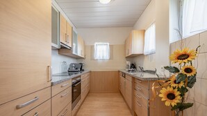 Una cocina con armarios de madera, una encimera y un ventanal.