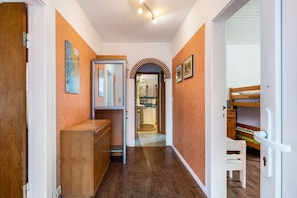 A hallway with wooden cabinets, a bench, and a door leading to a bathroom. - Holiday Apartment 'Caspersen' with Private Terrace, Private Garden and Wi-Fi (Viöl)