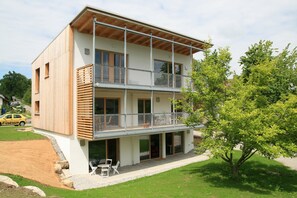 A modern two-story building with a balcony, a driveway, and a tree in front. - Apartment 'I I' with Balcony and Wi-Fi (Lindau)