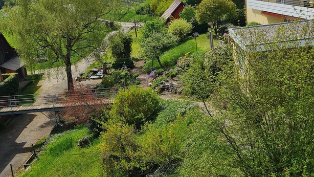A residential area with a house, a small building, and a view of a body of water. - Apartment 2 with Terrace (Stetten)
