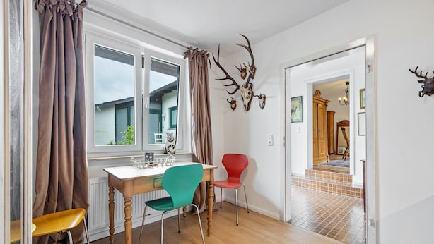 A dining area with a table, chairs, and a view of the outside.