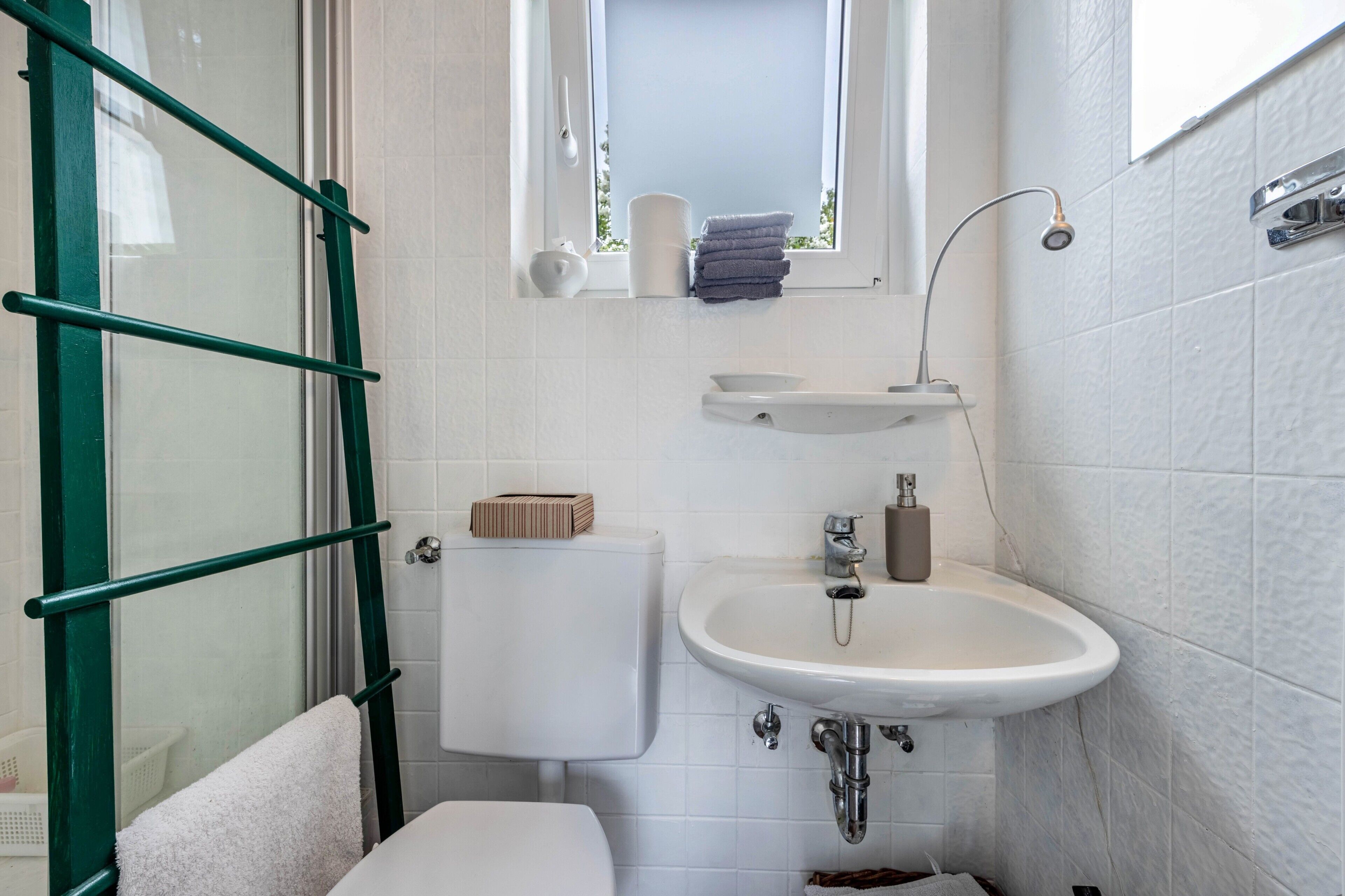 A bathroom with a toilet, sink, and shower.