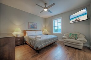 Primary bedroom features a king bed, TV, and ensuite bathroom. (Ridley Retreat)