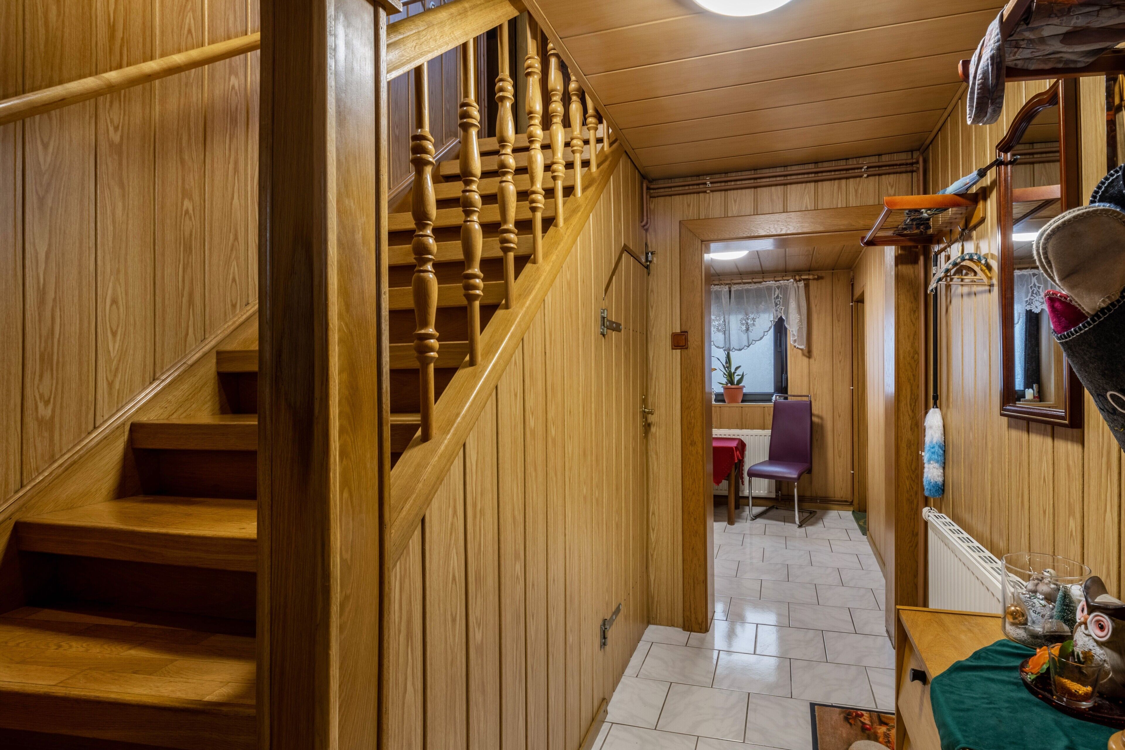 Eine Holztreppe führt zu einem Raum mit einem Stuhl und einem Tisch.