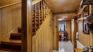 Una escalera de madera que conduce a una habitación con una silla y una mesa.