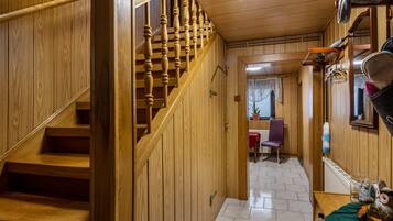Eine Holztreppe führt zu einem Raum mit einem Stuhl und einem Tisch.