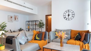 Una sala moderna con dos sofás, una mesa de centro y un reloj de pared.