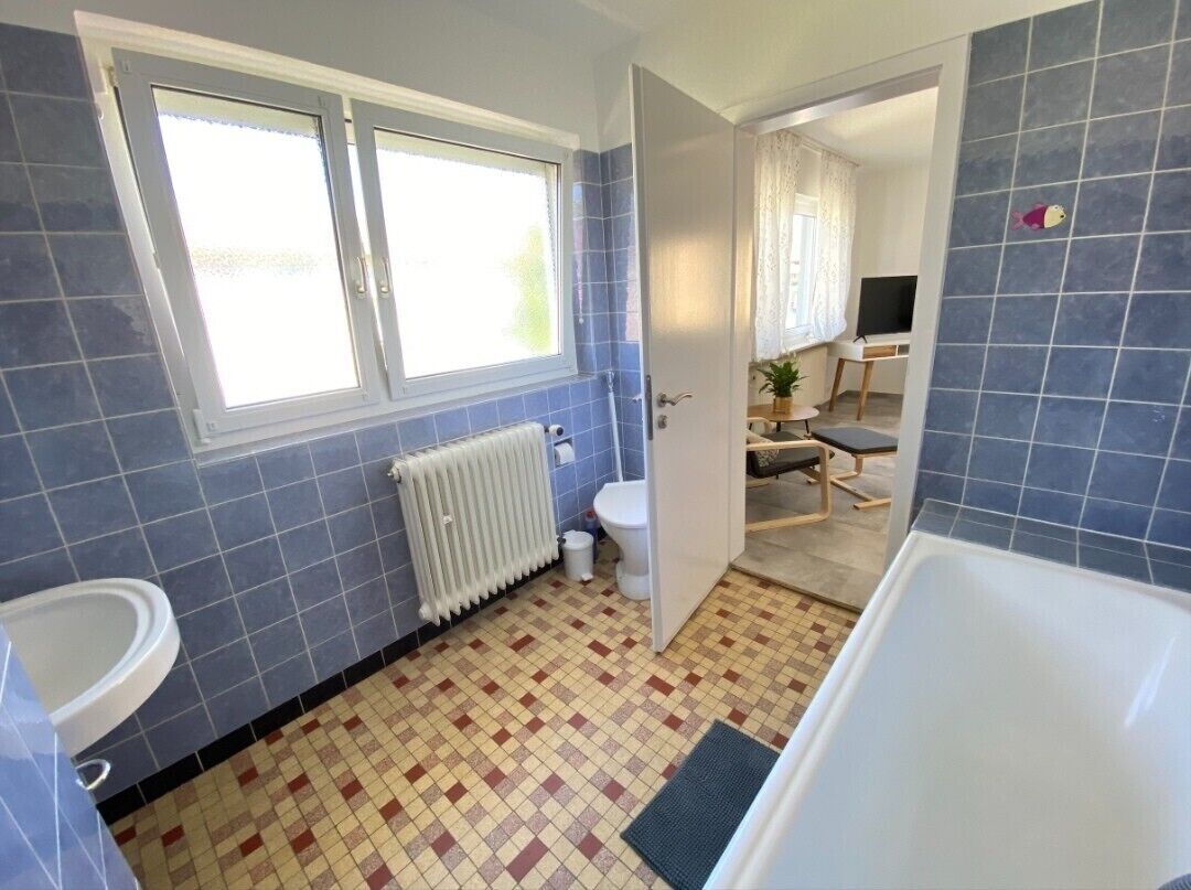Un baño con bañera, inodoro y ventana.