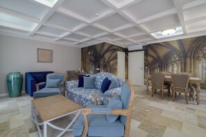 Ein geräumiger Wohnbereich mit einem gemusterten Sofa, einem Couchtisch und einem Esstisch.