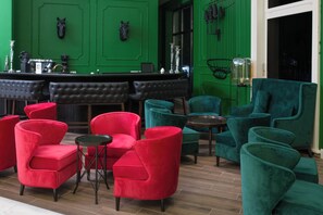 A bar area with green walls, red and teal chairs, and a black leather bar counter. - Eco Therma Village Spa & Sport (Balchik)