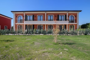 A two-story building with a flat roof, multiple windows, and a balcony on the upper floor. - Eco Therma Village Spa & Sport (Balchik)