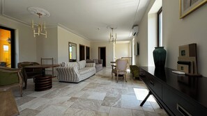 A spacious living area with a sofa, dining table, chairs, and a large TV. - Eco Therma Village Spa & Sport (Balchik)