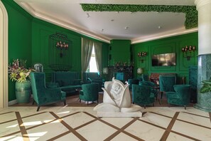 A green-themed lobby with plush seating, a birdcage wall decor, and a marble floor. - Eco Therma Village Spa & Sport (Balchik)