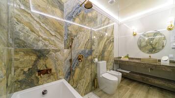 Une salle de bain moderne avec un mur en marbre, une baignoire sur pieds, des toilettes et un meuble-lavabo avec un miroir.