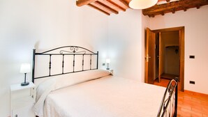A bedroom with a bed, bedside tables, and a wooden ceiling.