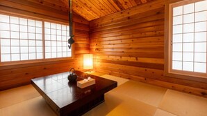 A traditional Japanese room with tatami flooring, a low wooden table with a lamp, and shoji screens. - SHODOSHIMA PRIVATE CAMP SITE (Shodoshima)