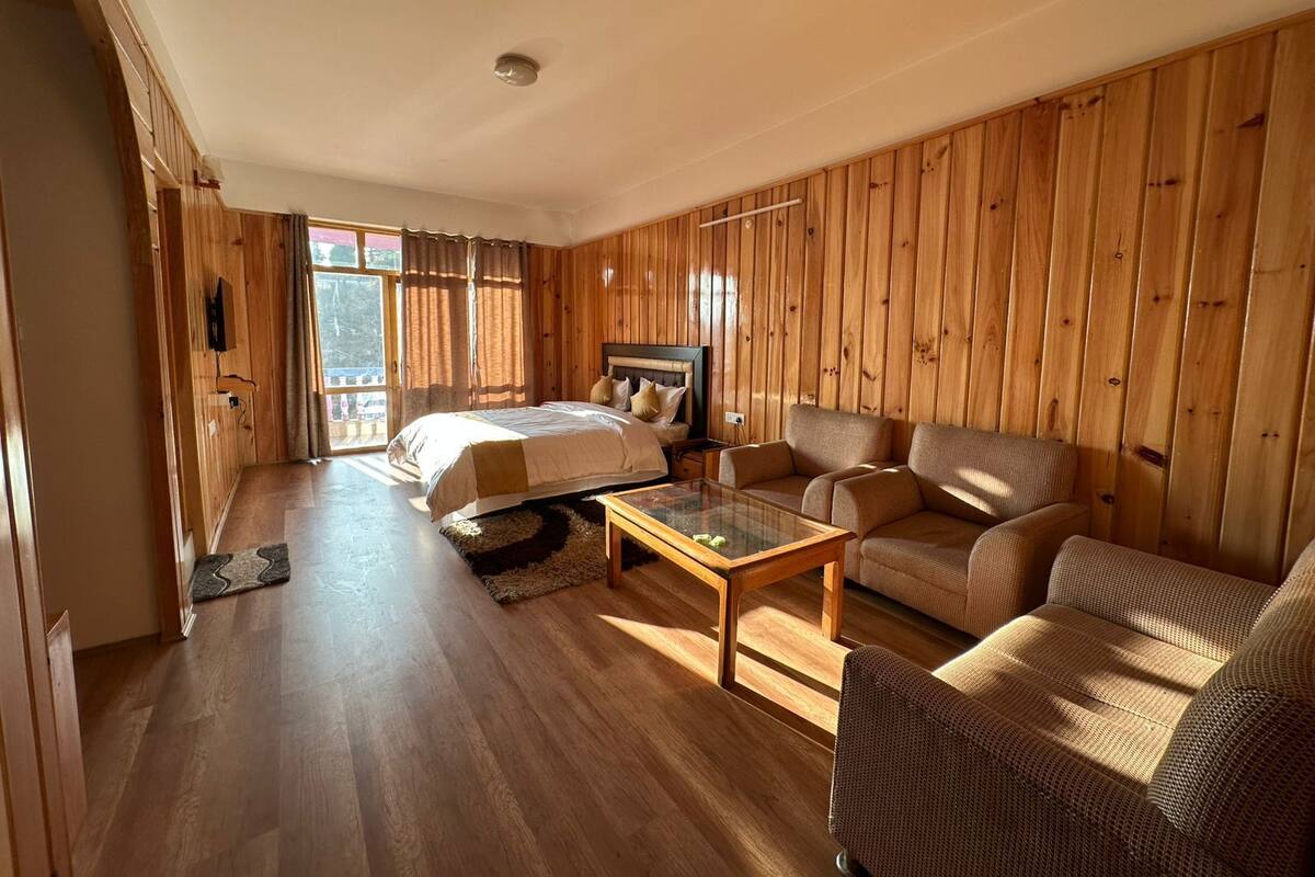 A wooden-paneled room with a bed, sofa, and coffee table.