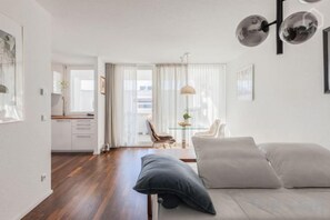 Un salon moderne comprenant un canapé, une table basse et un coin repas avec une table et des chaises.