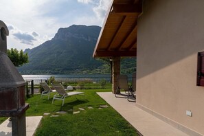 Eine Terrasse mit Liegestühlen mit Blick auf einen See und Berge.