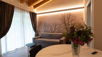 Een moderne woonkamer met een bank, een eettafel en een bloemenvaas.