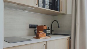 Une cuisine moderne équipée d’un four à micro-ondes Bosch, d’une miche de pain sur une planche à découper et d’une machine à café.