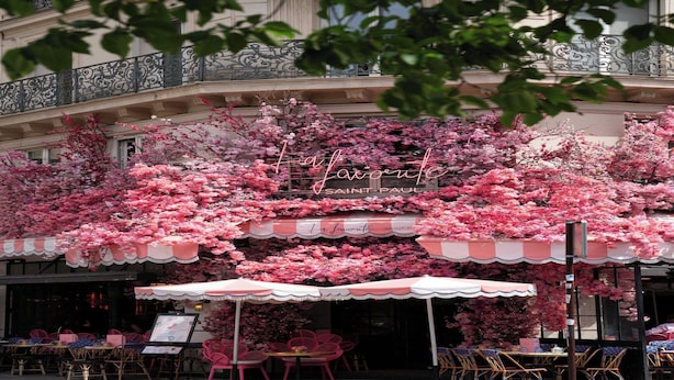A café with outdoor seating, covered by a striped awning, and surrounded by blooming pink flowers. - Comfortable Apartment - 1BR/2P - Arts et Métiers (Paris)