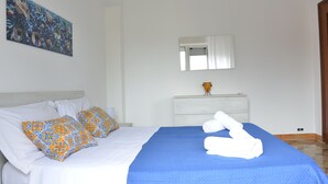 A neatly made bed with a blue bedspread, white pillows, and a blue blanket. - Penta Dream House "DORY" (Sicilia)