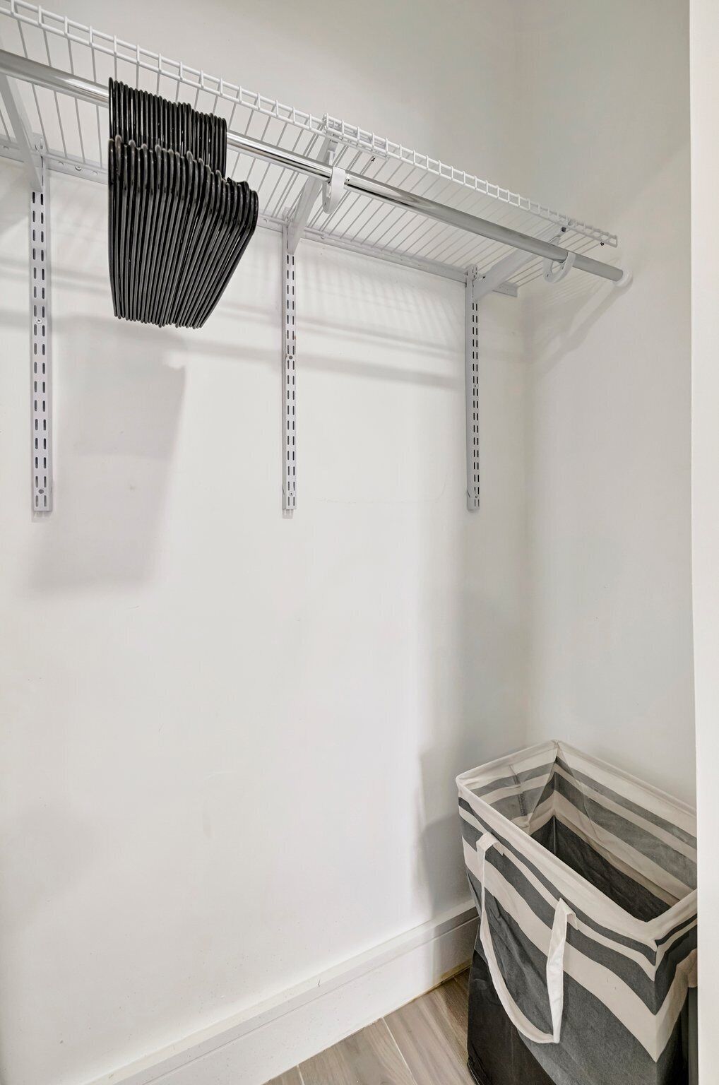 Un espace de rangement doté d’étagères métalliques et d’un grand bac de rangement gris.