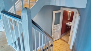 Un escalier avec des rampes blanches menant à un palier.