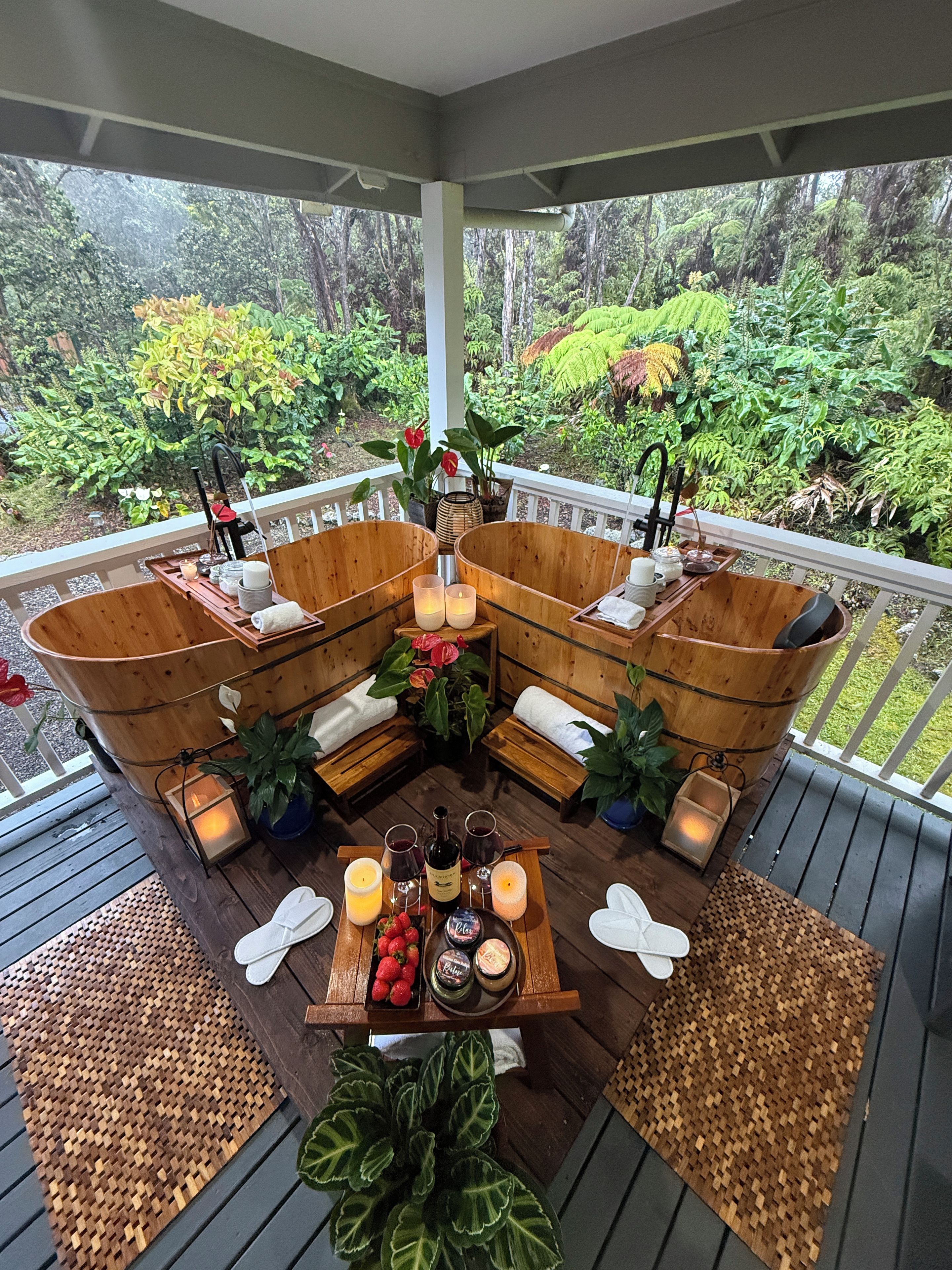 Een overdekt terras met houten meubels en een gedekte eettafel, met uitzicht op een weelderige tuin.