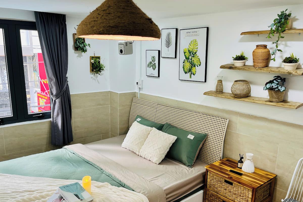 A neatly arranged bedroom with a bed, bedside table, and a small wooden nightstand.