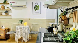 Eine moderne Küche mit Essbereich, ausgestattet mit einer schwarzen Arbeitsplatte, weißen Stühlen und einem Tisch mit kariertem Tischlein.