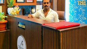 A reception desk with a wooden finish, a clock, and framed certificates on the wall. - The Nest Ayodhya (Faizabad)