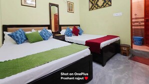 A hotel room with two beds, a mirror, an air conditioner, and a door leading to a bathroom. - The Nest Ayodhya (Faizabad)