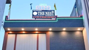 A building with a sign reading "THE NEST" and "AC & NON AC ROOMS AVAILABLE". - The Nest Ayodhya (Faizabad)