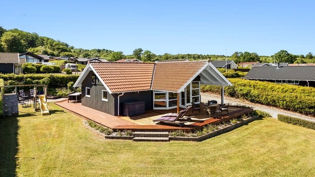 Een modern huis met een schuin dak, een terras en een patio.