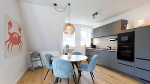 Una cocina moderna con armarios grises, una mesa de comedor de madera y sillas azules.