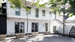 Un edificio moderno con fachada blanca, un balcón y una escalera.